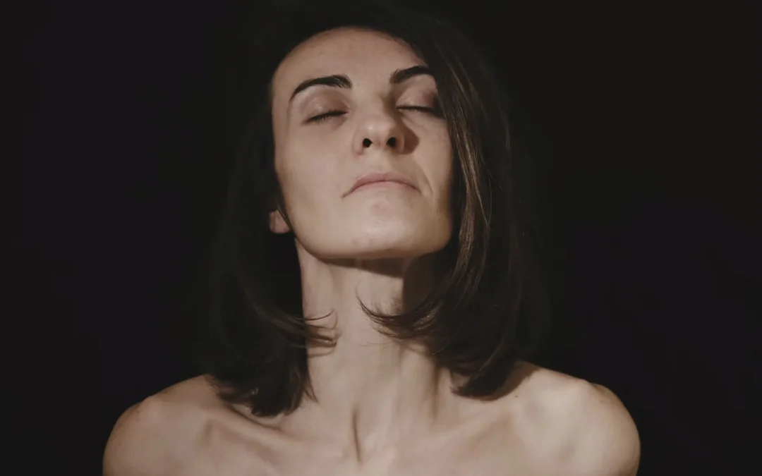 Mujer madura tocando su rostro frente al espejo, luego de lifting facial con resultados naturales.