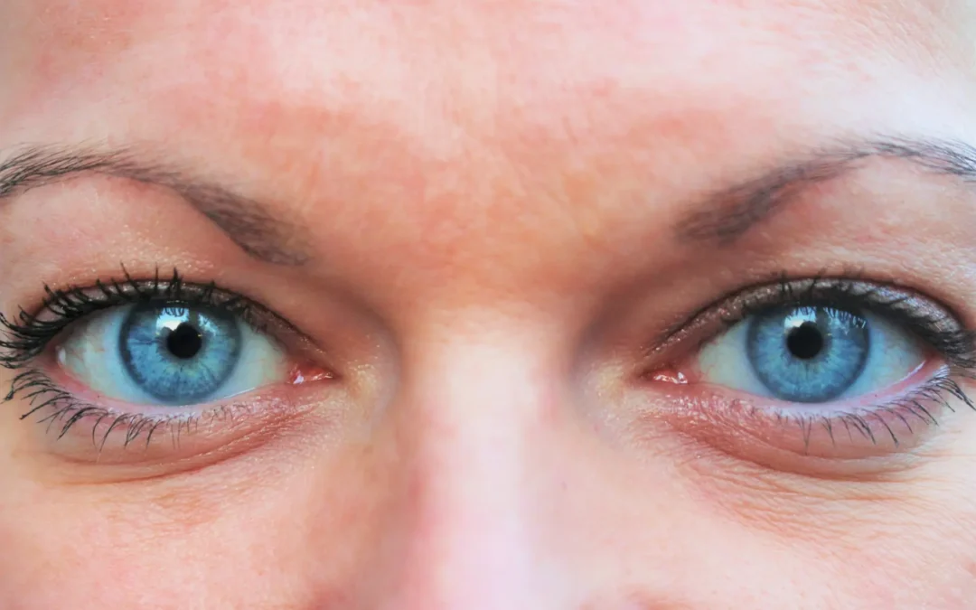 Mujer de mediana edad mirándose al espejo con expresión suave, resaltando una mirada rejuvenecida.